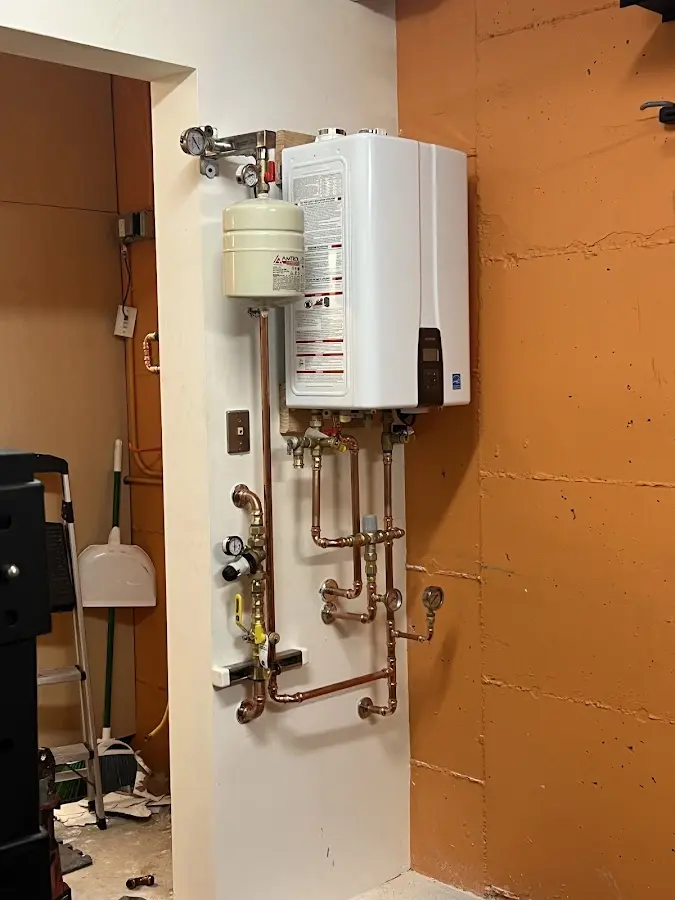 Plumbing technician inspecting water heater connections in Seymour